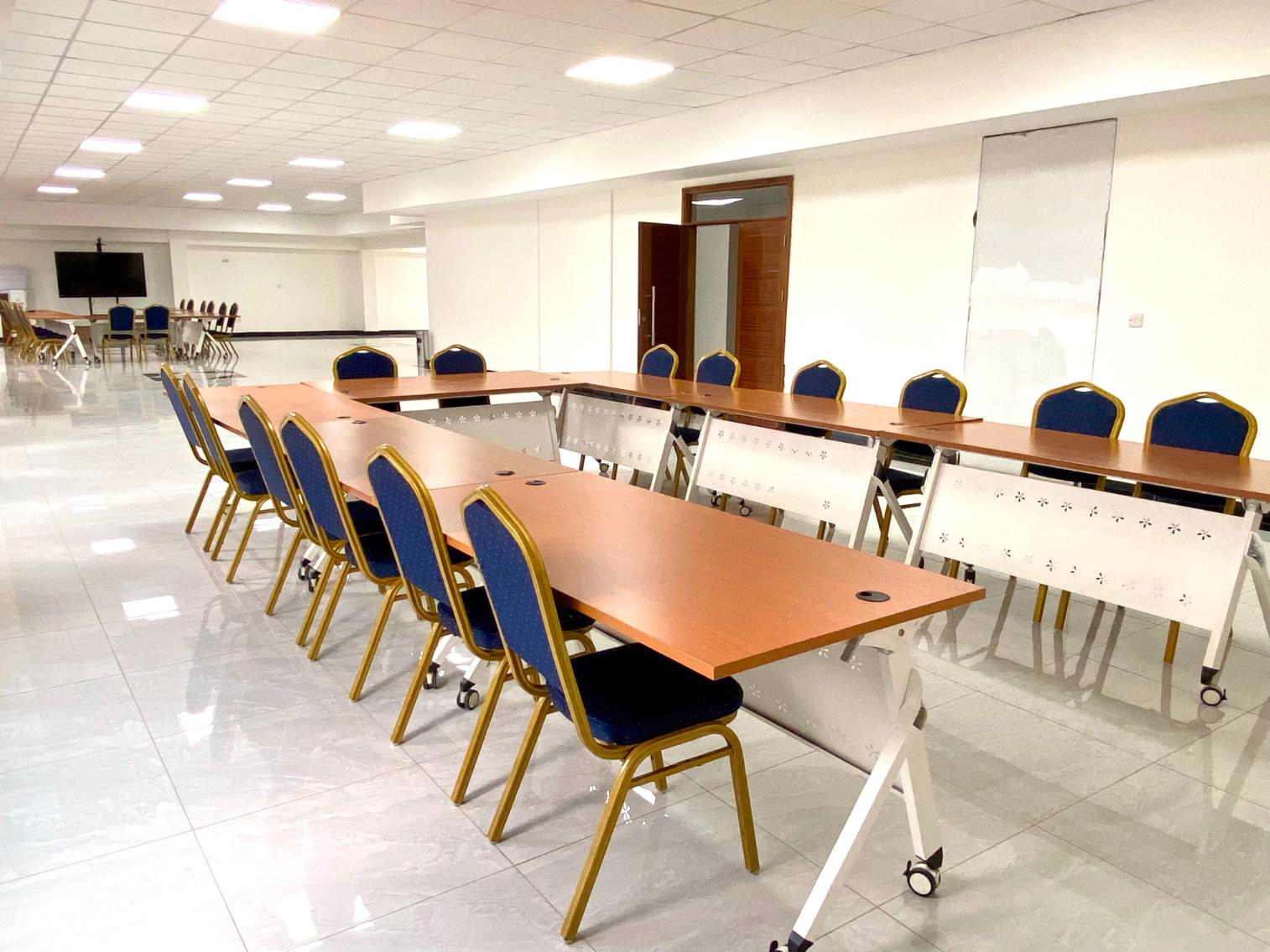An Enwealth conference room set with long tables and chairs, a screen at the front