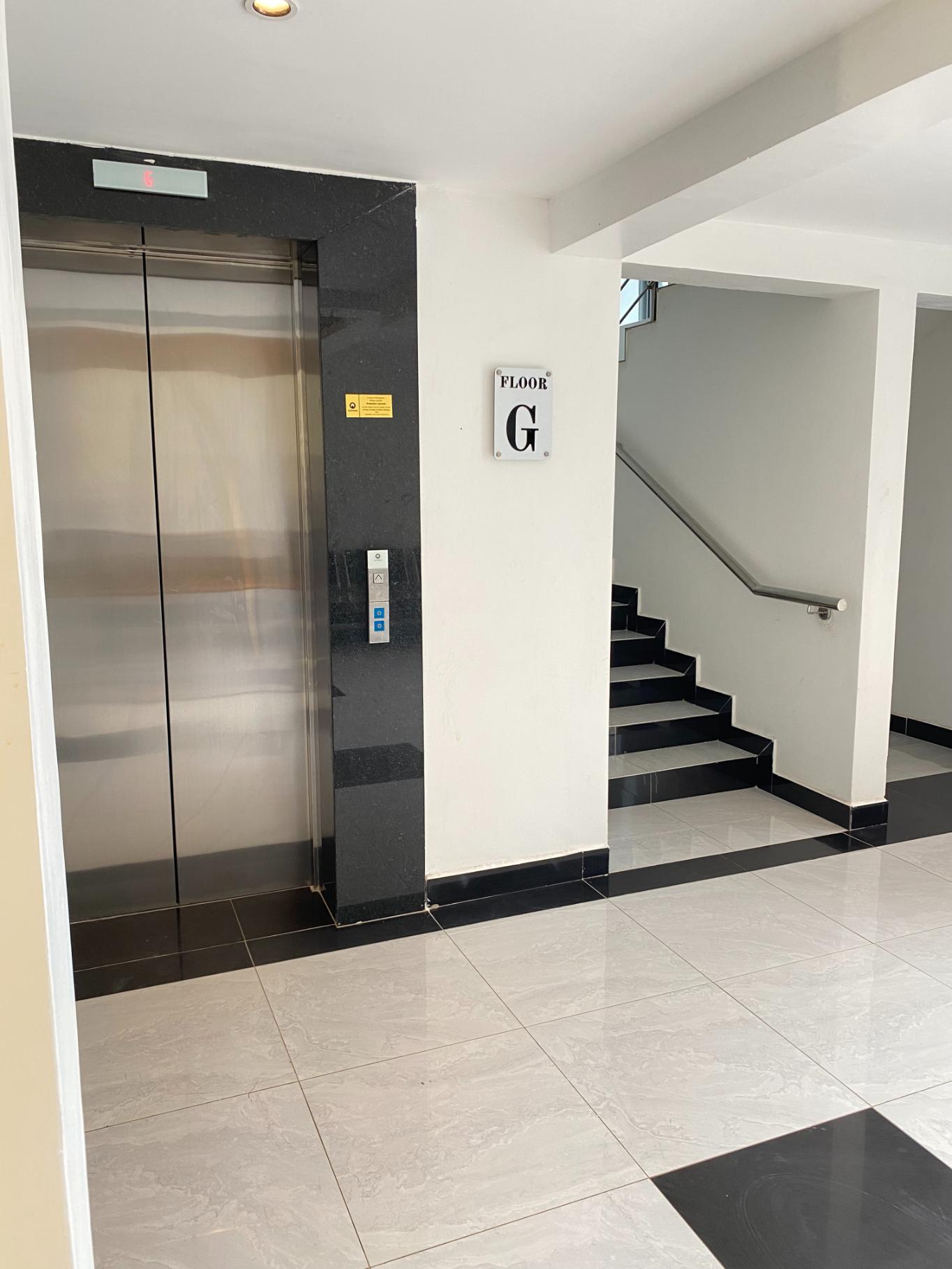 A lift lobby and staircase in Enwealth's building