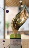 A gold flame-shaped award trophy on a wooden base