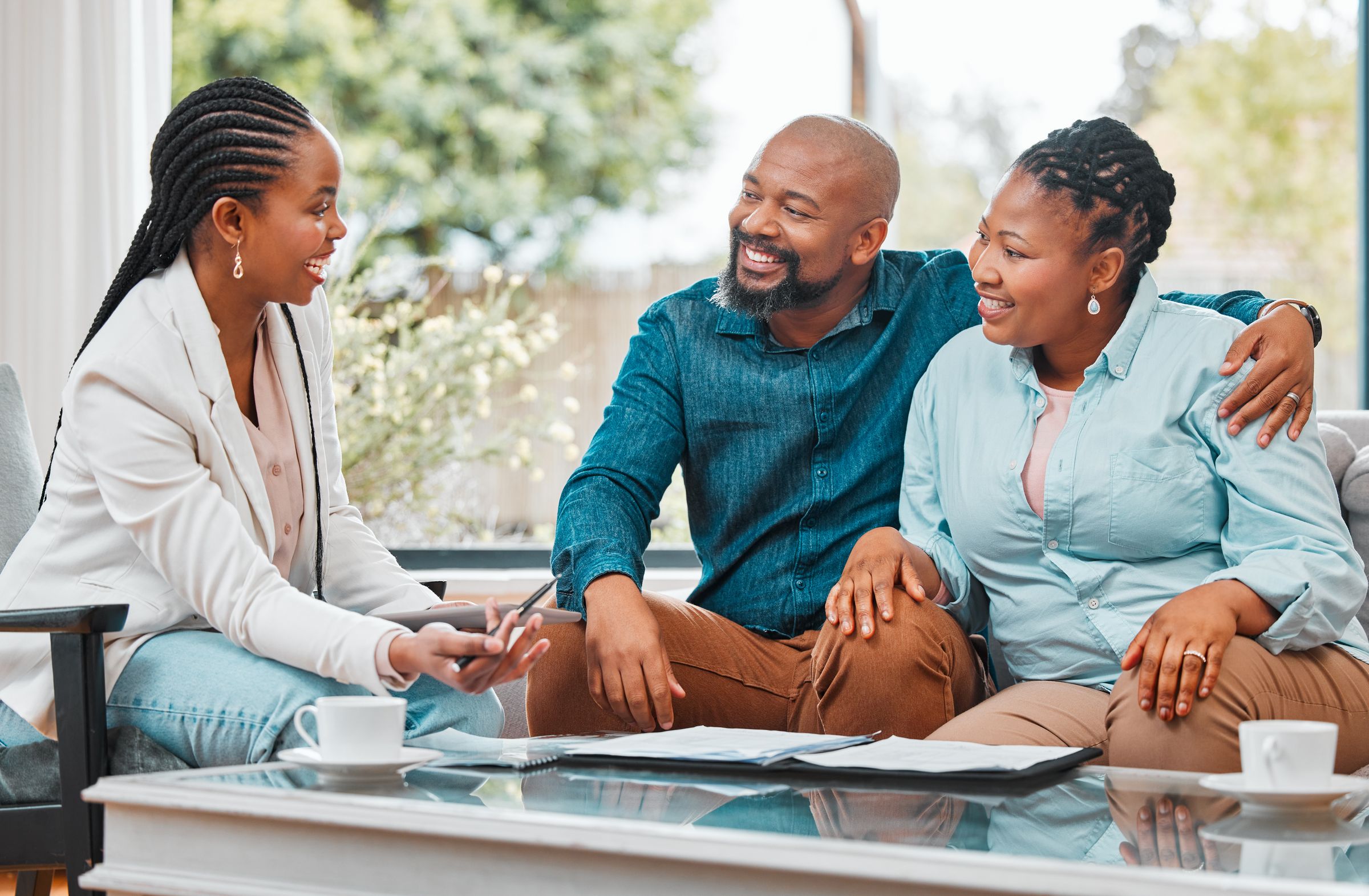 An adviser talking a smiling couple through their finances at home
