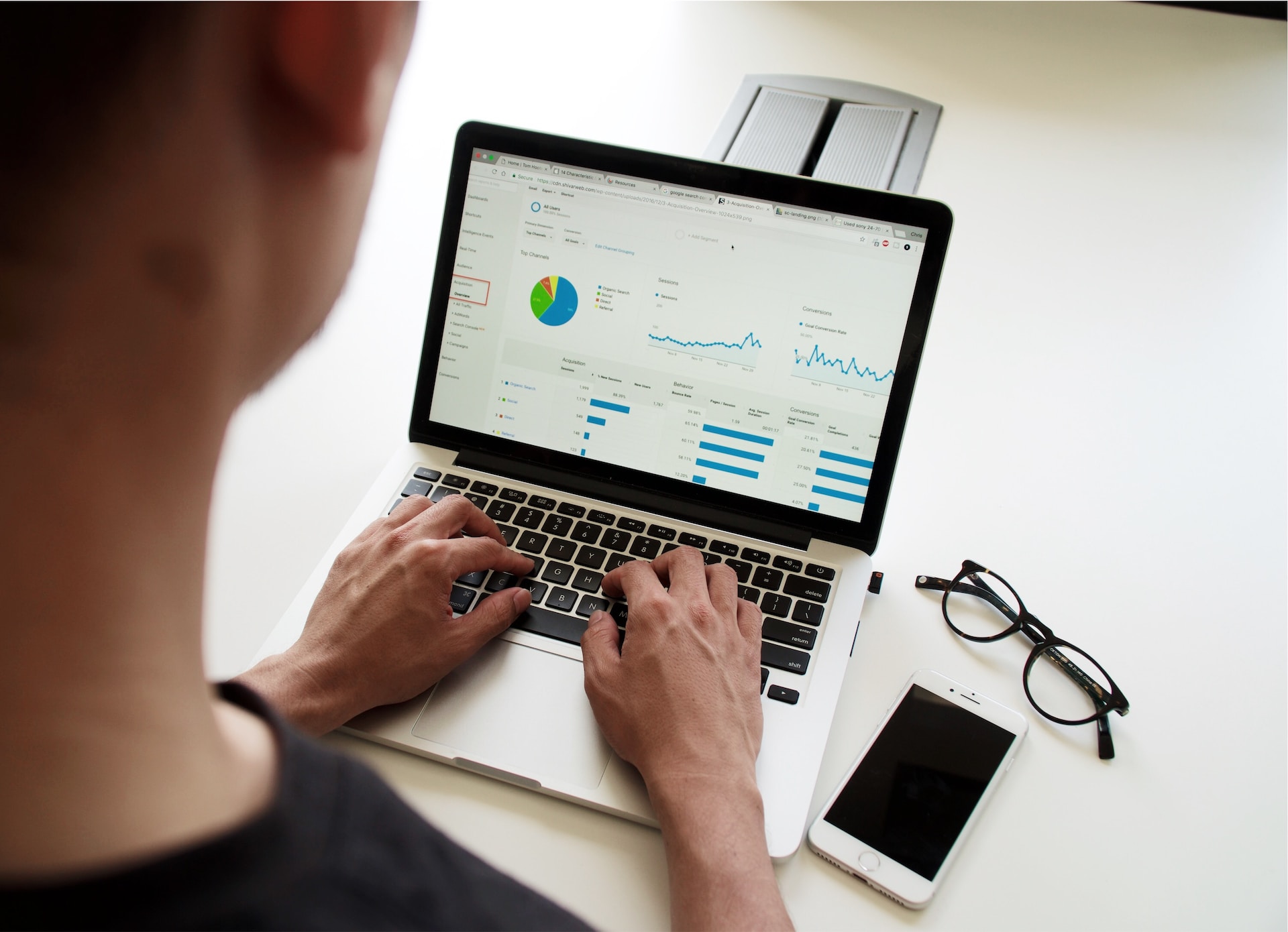 A person working on a laptop showing a dashboard of charts