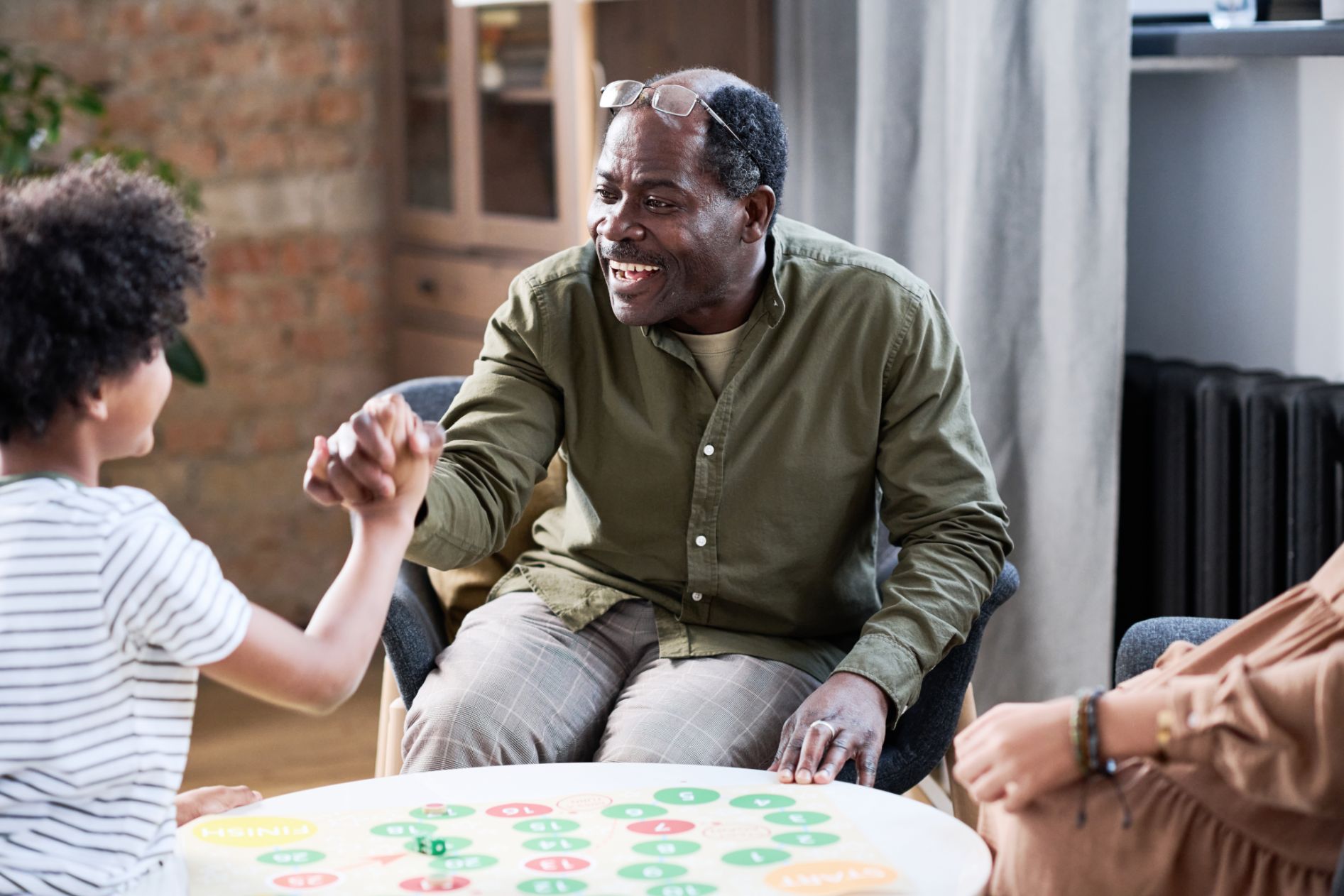 An older man and a child playing a board game at home